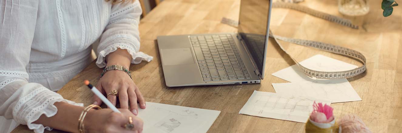 Young woman working on laptop and taking notes