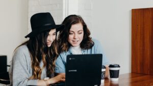 Two female teenagers working on a laptop together