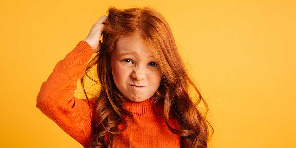 Confused young girl scratching head
