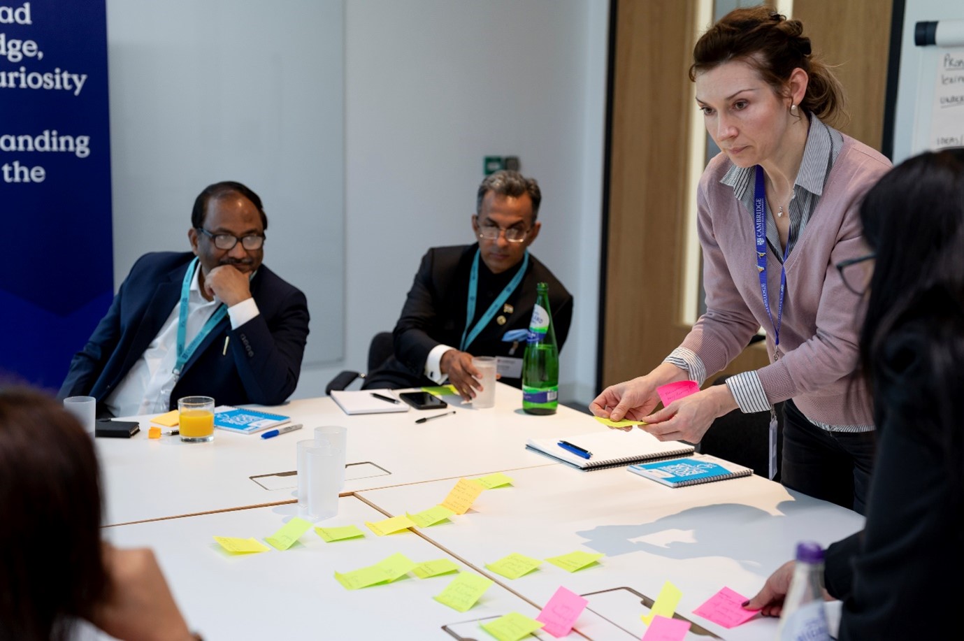 Delegates around a table discussing the post-it notes in front of them