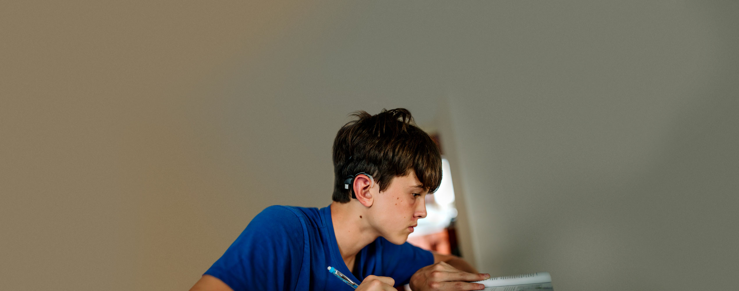 Boy with hearing aid studying