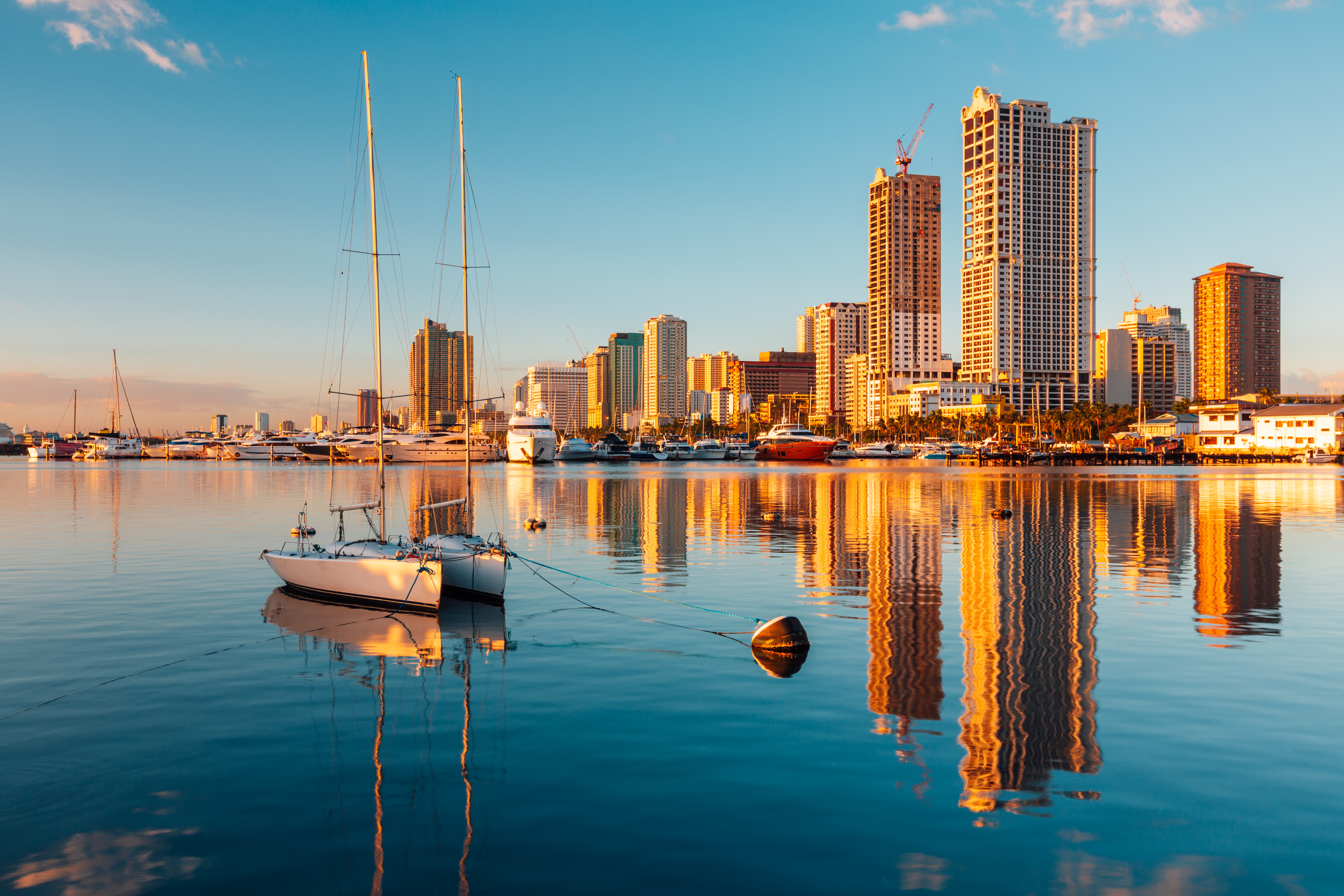 A boat and skyscrapers making up image of the skyline at Manila bay