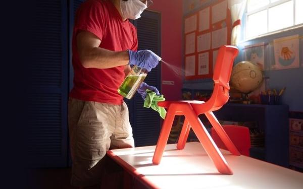 Man in mask cleaning chair 