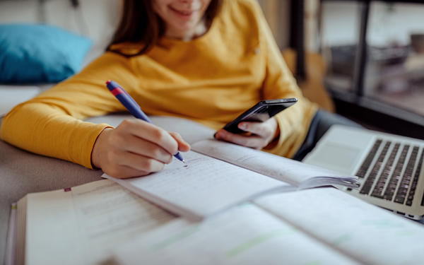 A female student is using AI chatbot on phone to help with her homework
