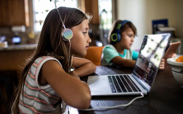 girl with headphones watching on laptop