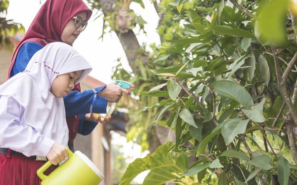 teacher and student watering plants