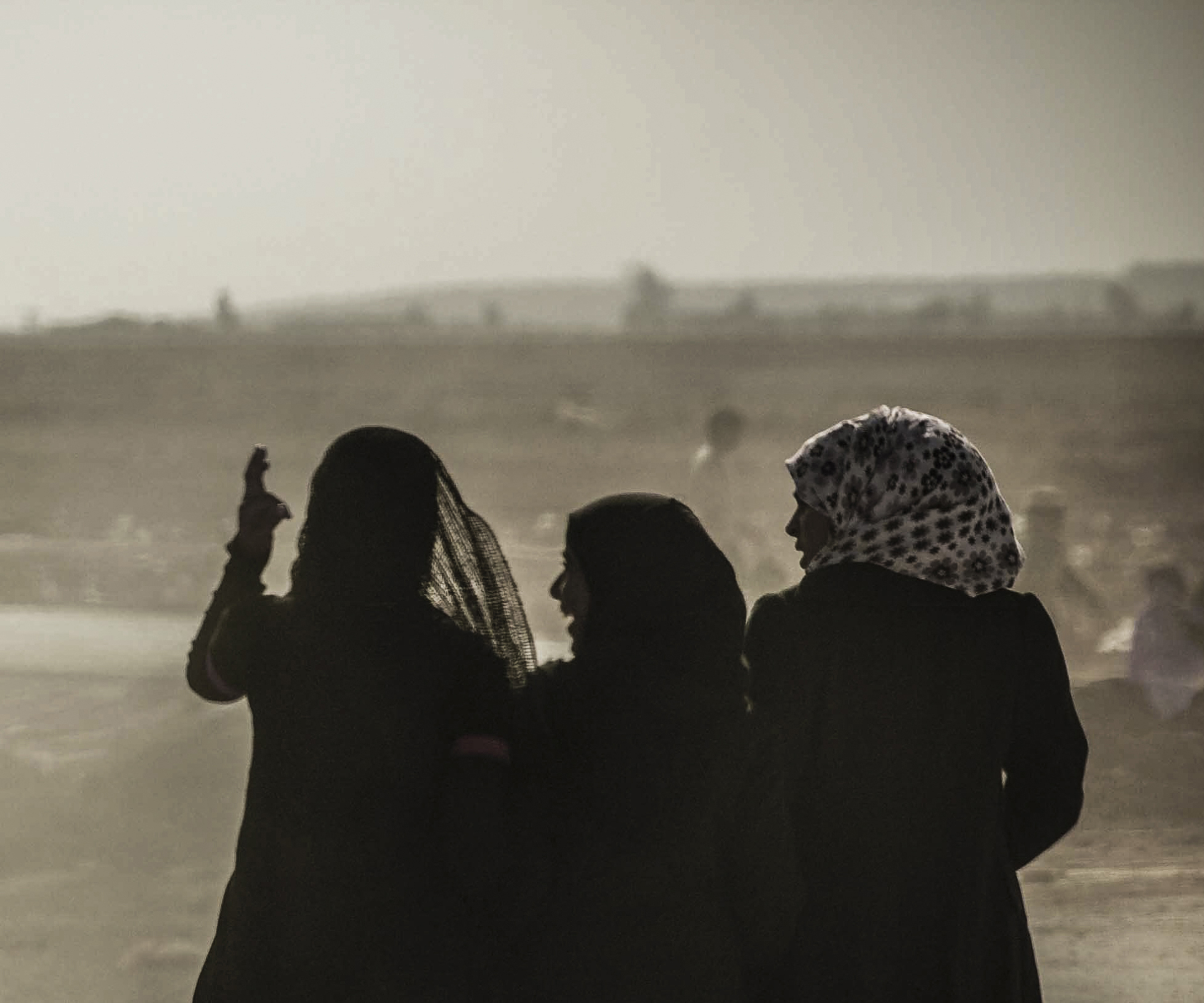 The backs of three women standing together